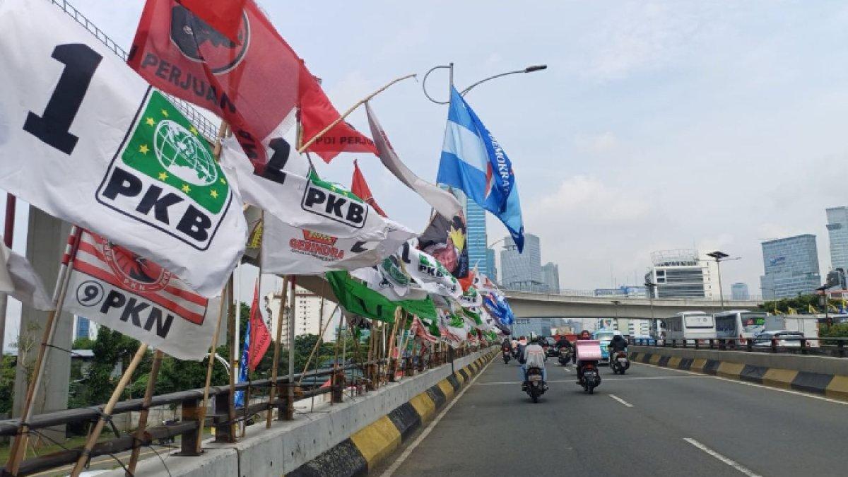 Sejumlah bendera parpol di flyover Kuningan, Mampang Prapatan, Jakarta Selatan ditertibkan karena sempat roboh dan celakai pasangan lansia [tribunnews]